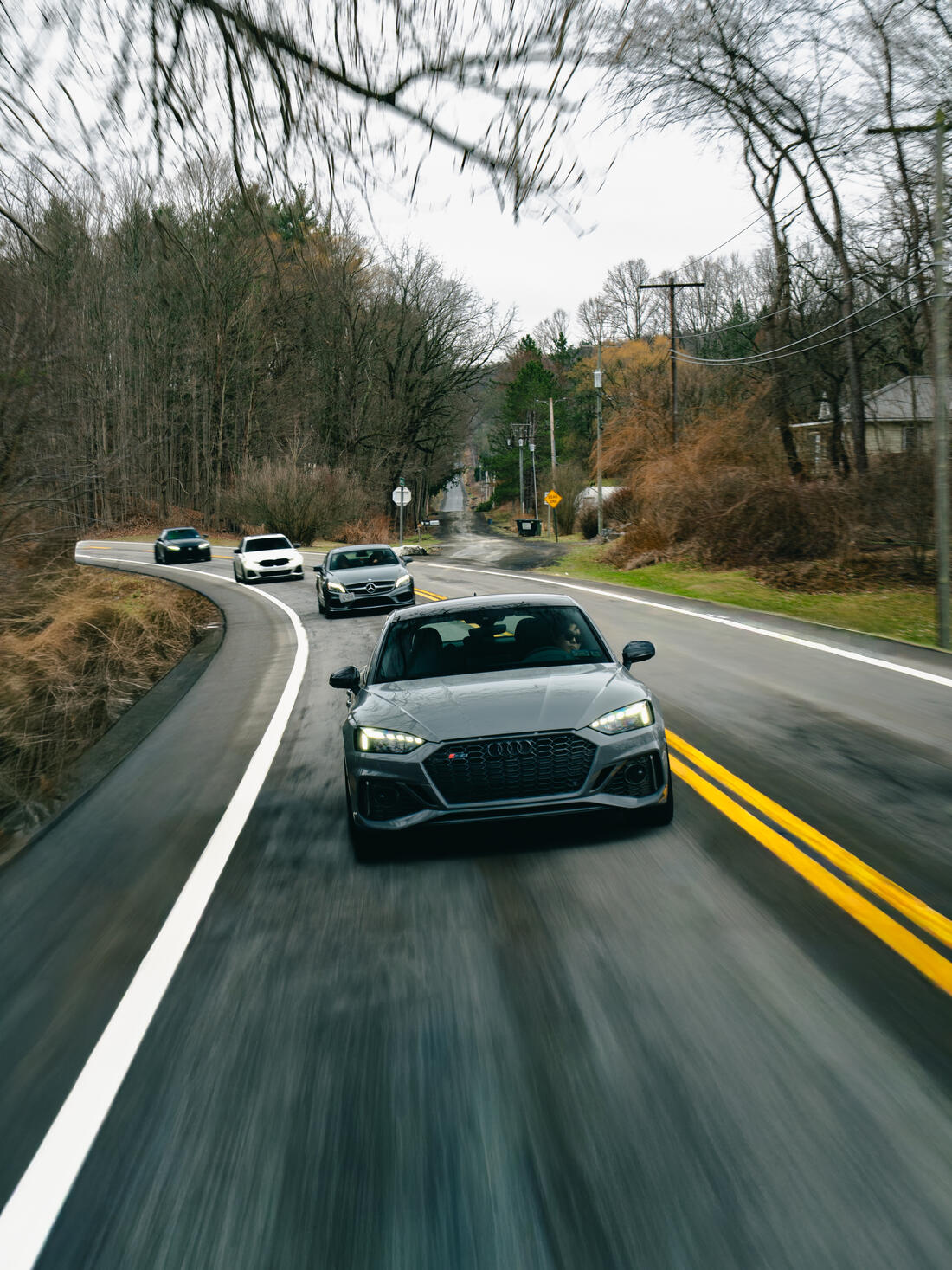 View from a passenger window of club cars running ahead on a country road