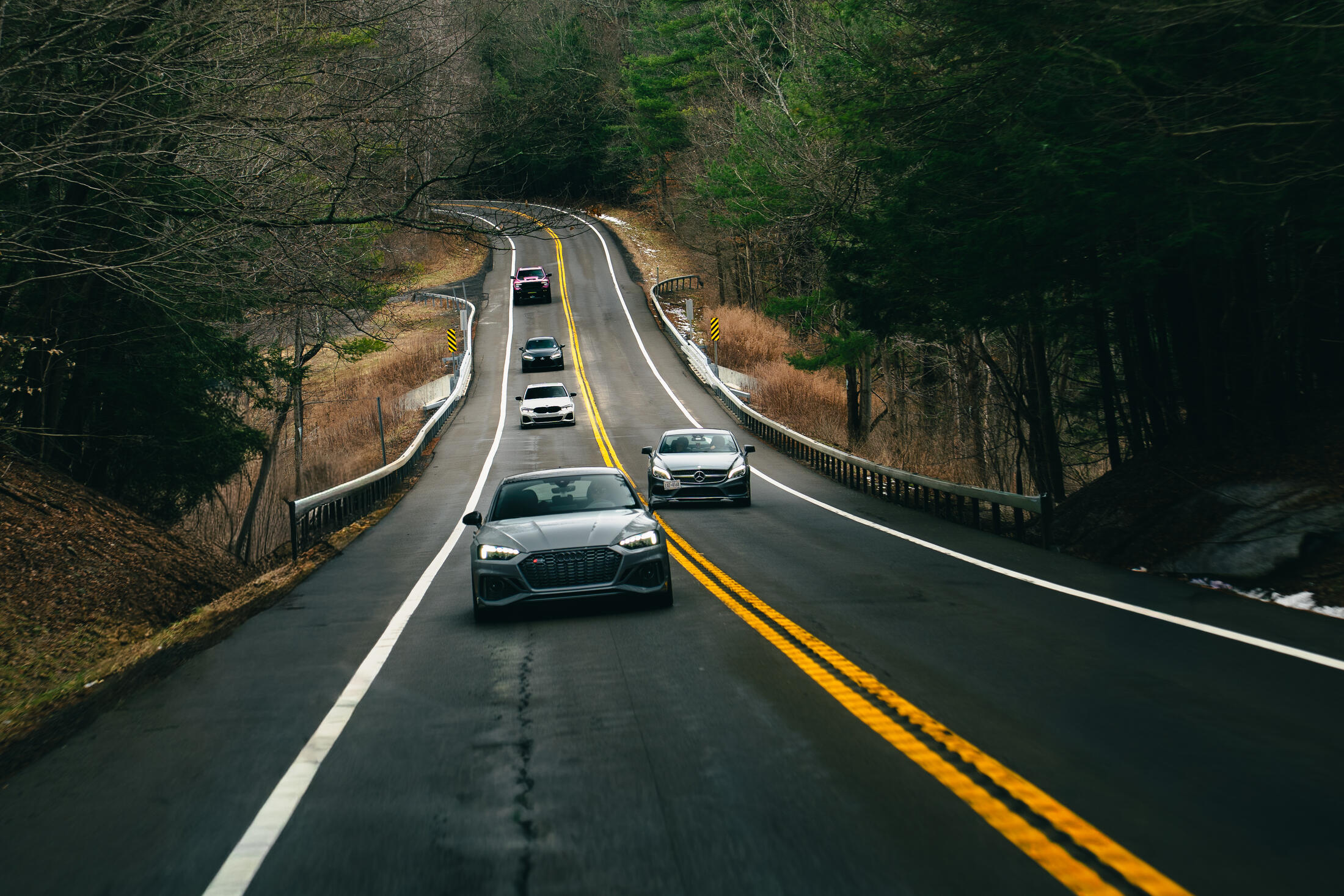 A line of club cars running together on a two-lane road outside Ithaca